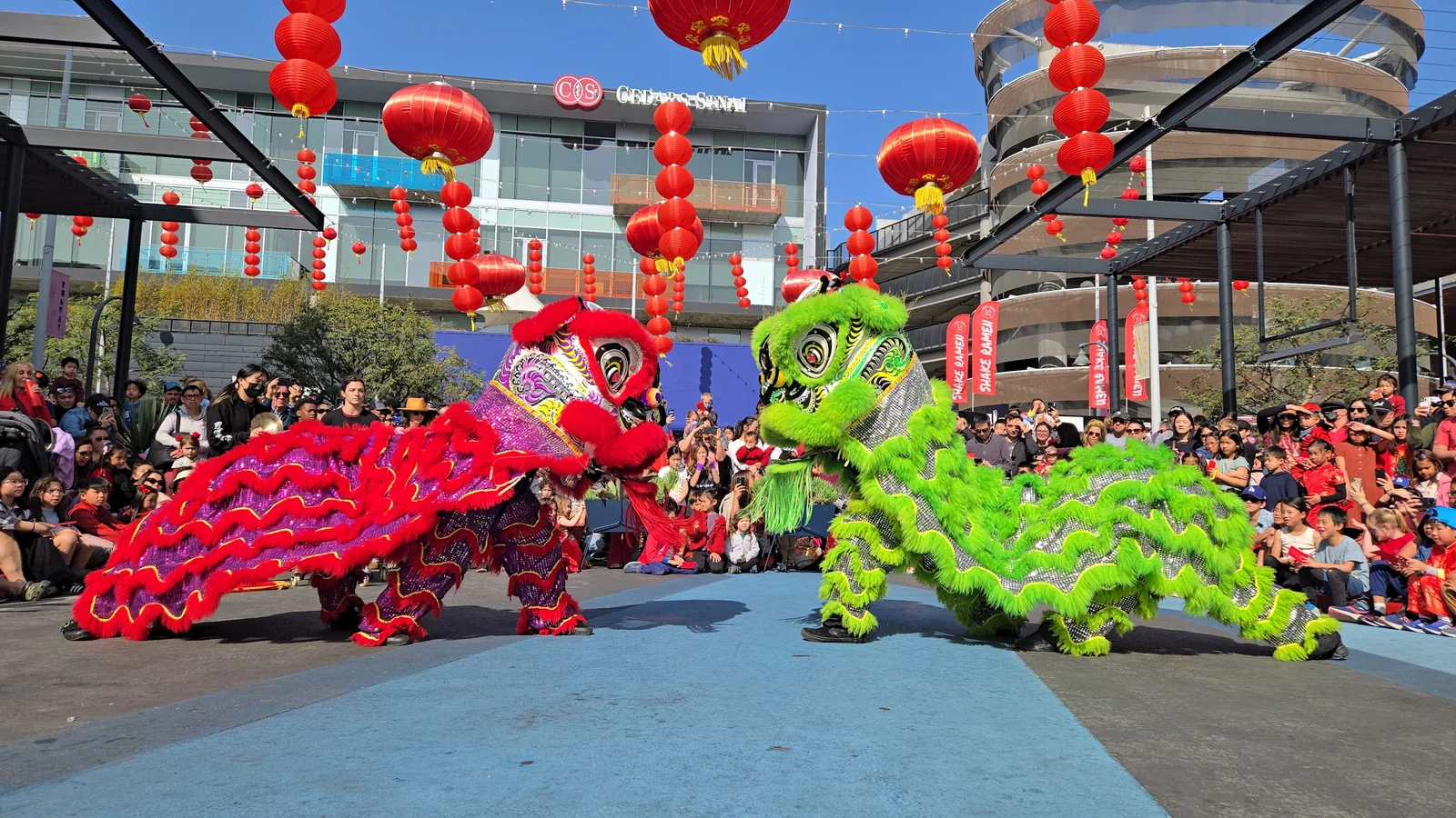 Dueling lion dance performers under red lanterns at the 2025 Runway Lunar New Year Celebration